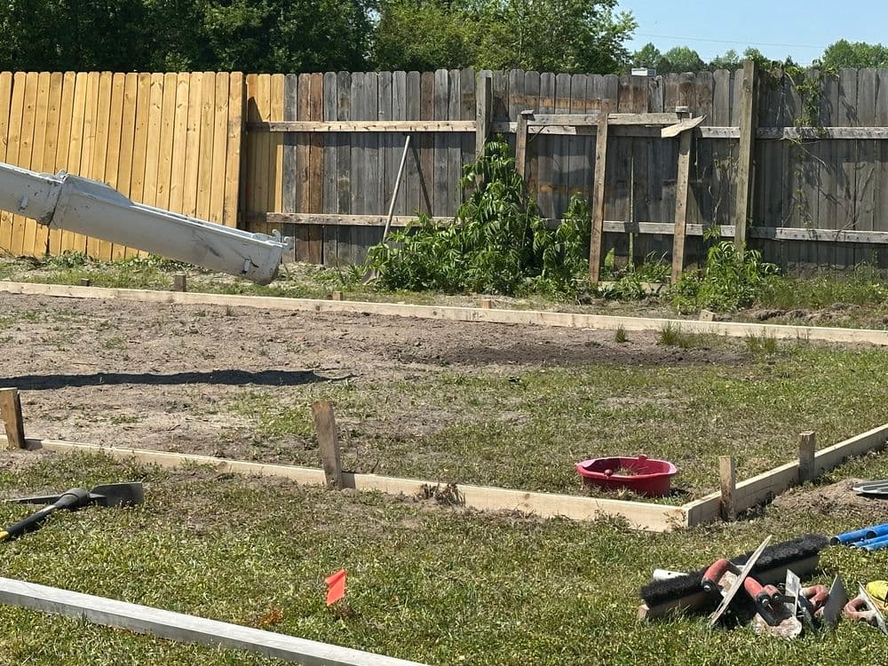 Construction site with wooden framework, tools, and fenced area ready for building.