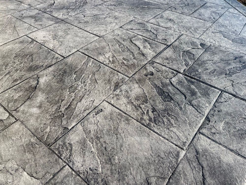 Textured gray stone patio tile with a natural rock pattern, ideal for outdoor spaces.