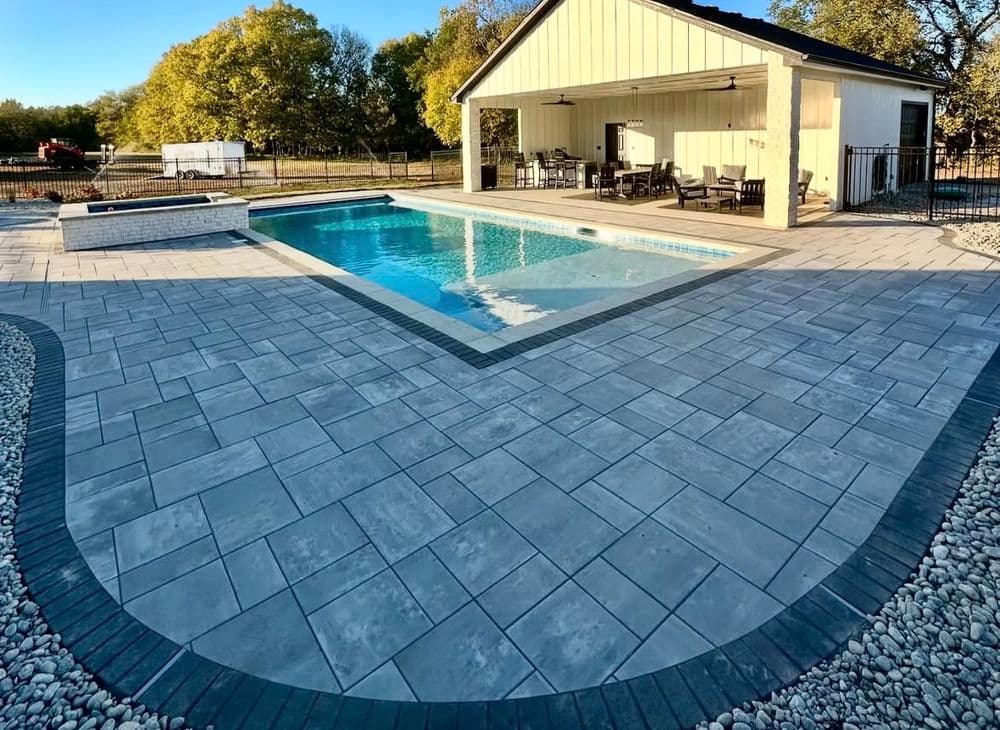 Modern backyard pool area with stylish patio, outdoor seating, and shaded pavilion.