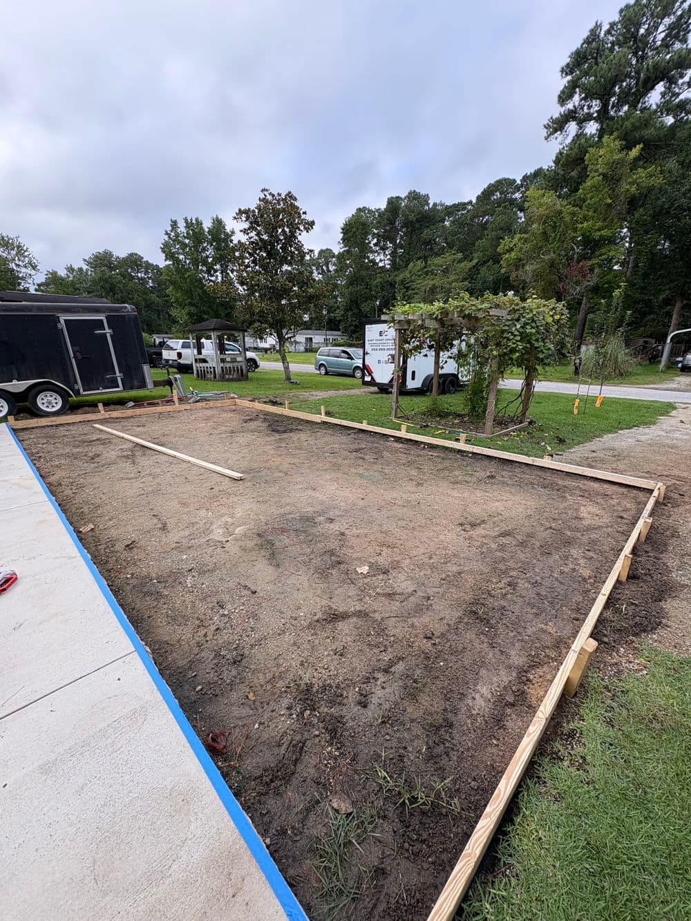Construction site with wooden framing for concrete slab in a residential area.